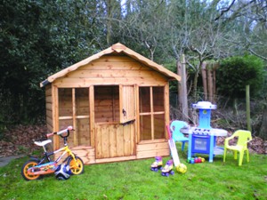 Wooden playhouse and toys on lawn