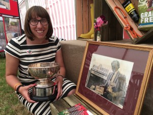 Beth holding cup next to JB photo