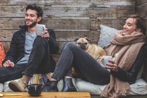 Couple with dog cosy and drinking coffee 