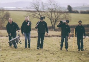 Team of men walking in field