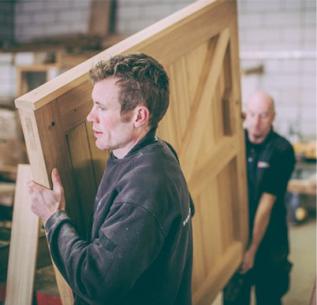 John Bright craftsmen carrying large wooden gate