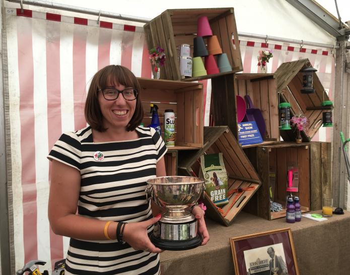 Beth Bright holding winning trade stand trophy