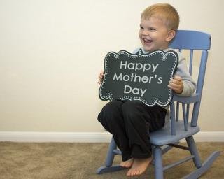 Child with chalk board sign Happy Mother's Day