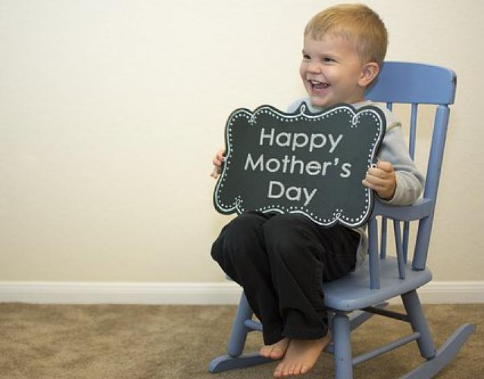Child with chalk board sign Happy Mother's Day