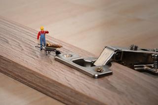 Tiny workman with screw and wheelbarrow