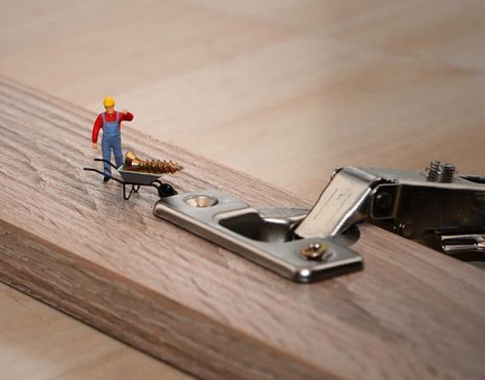 Tiny workman with screw and wheelbarrow