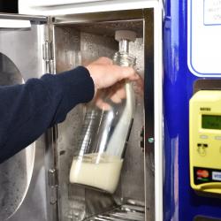 Milk pouring into glass bottle